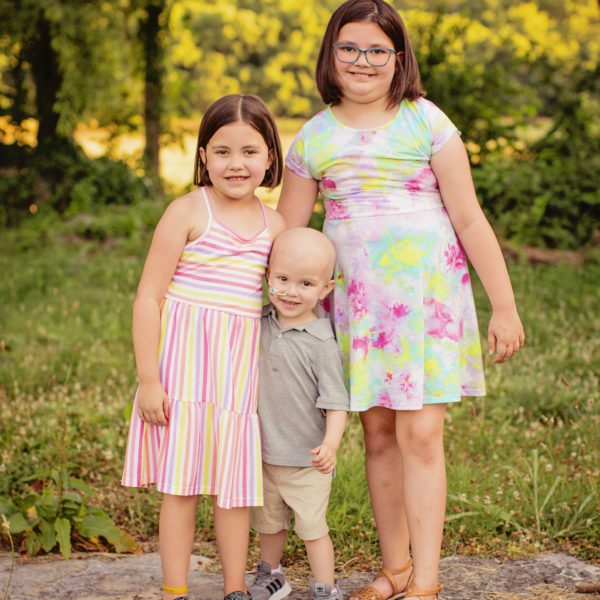 Courageous Kid fighting cancer Merrick standing with his sisters Rhylee and Payslee